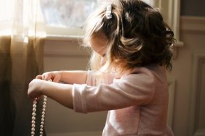 A girl holding a necklace