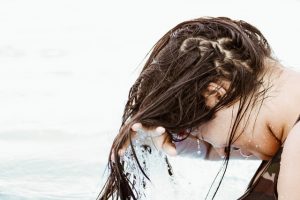 An adult washing hair with baby shampoo